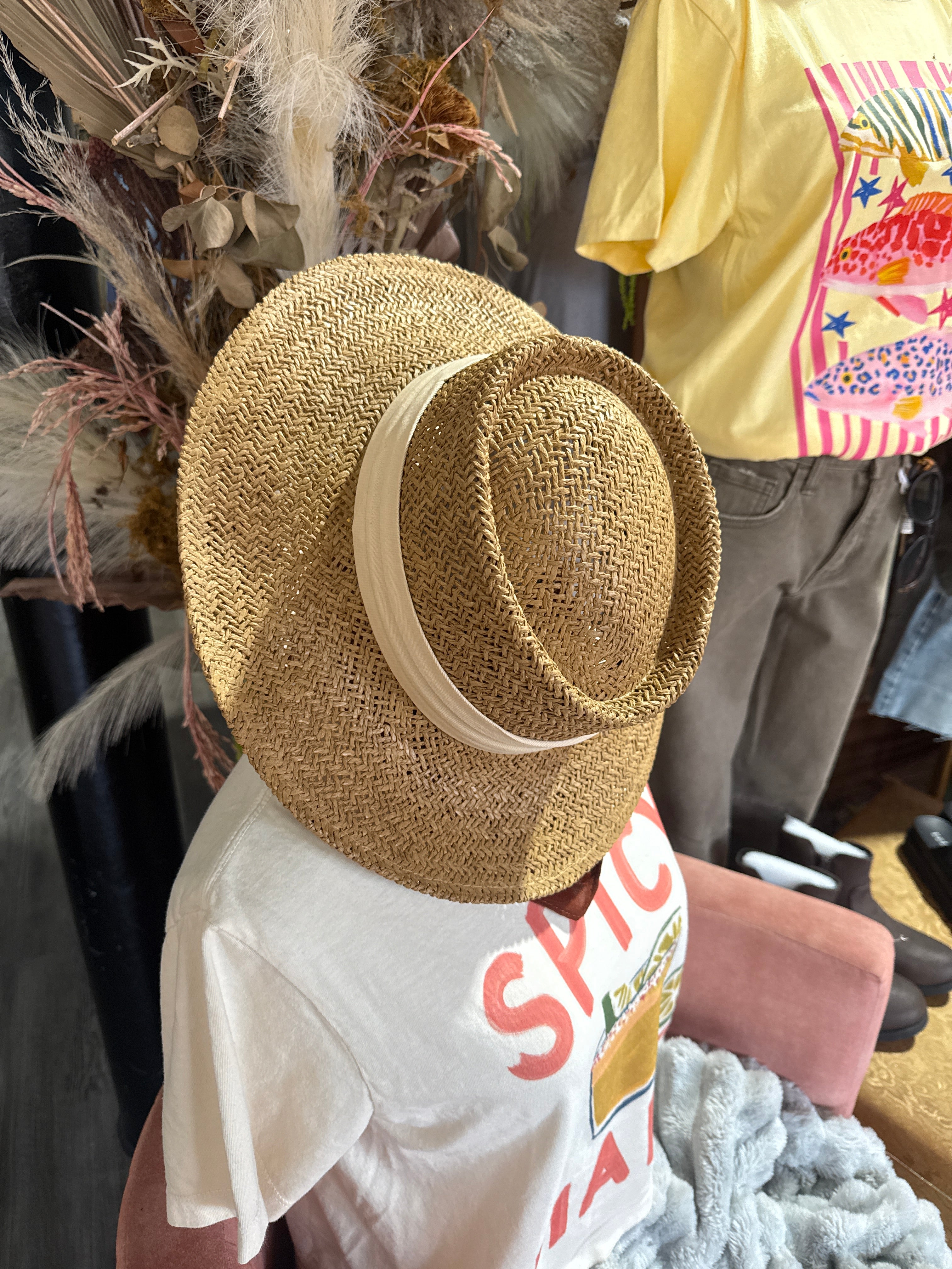 Wide-brim straw beach fedora hat with a cream ribbon band from Quotes + Cotton boutique in Burlington, WI.