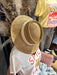 Wide-brim straw beach fedora hat with a cream ribbon band from Quotes + Cotton boutique in Burlington, WI.