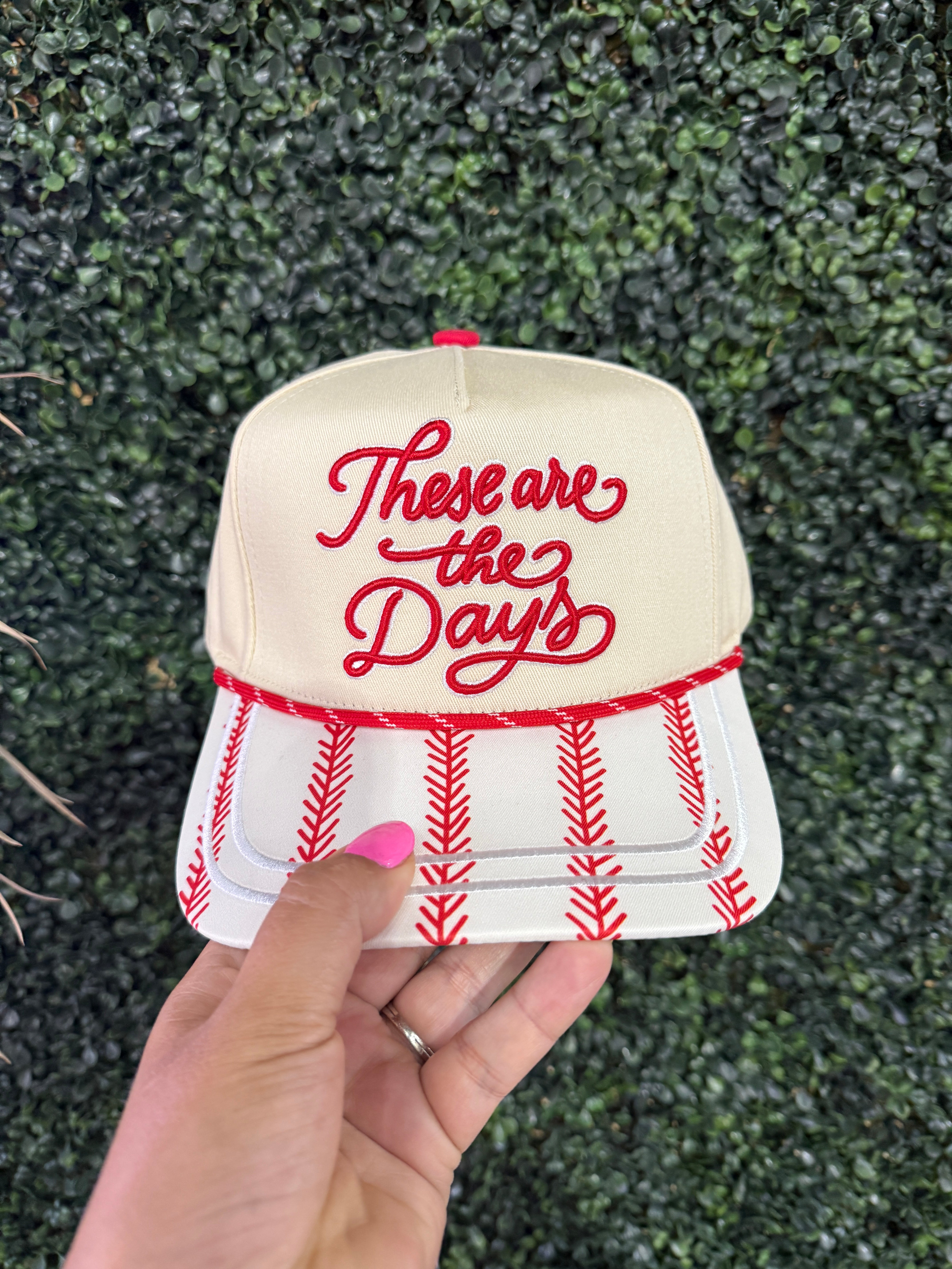 trucker hat with red and white stitching and embroidering that says these are the days 